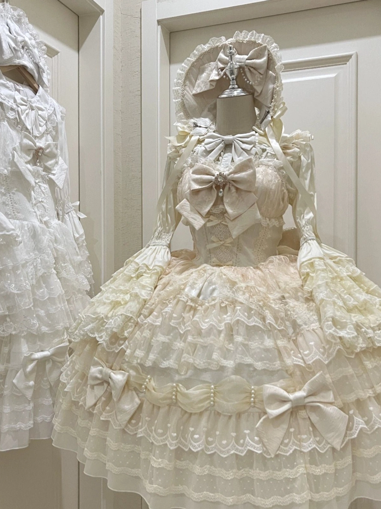 Cream beige Lolita JSK dress suit with tiered lace skirt pearl waist trims multiple satin bows and bow-adorned bodice front