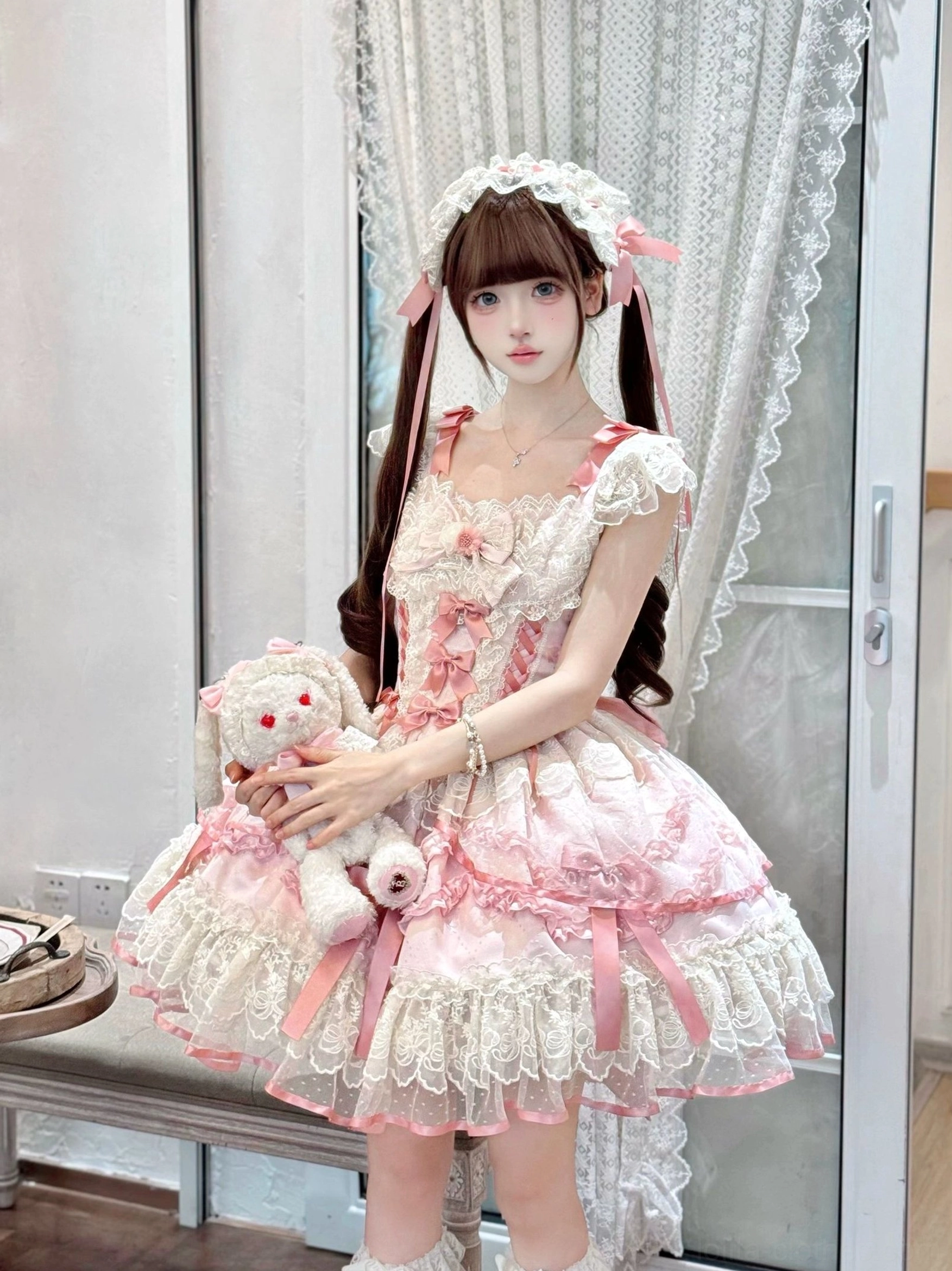 Pink Dreamy Butterfly JSK front view indoor afternoon tea studio, layered lace skirt, front ribbon bows, matching hair headdress, twin-tailed model hugging plush rabbit doll