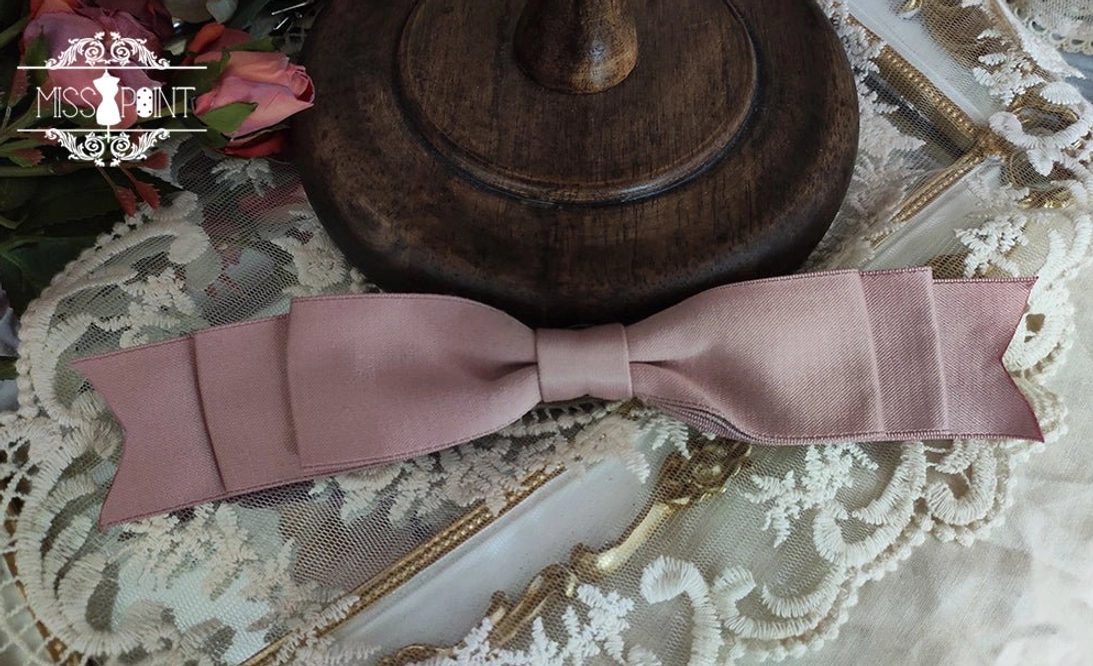Dusty pink pleated satin bow waist accessory for romantic Lolita coordinates displayed with roses and vintage decor