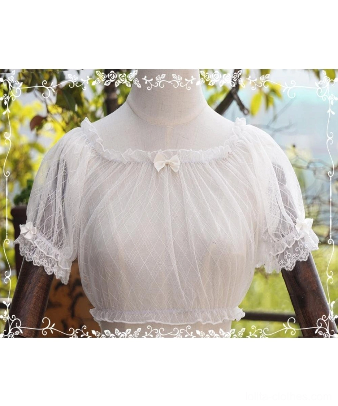 White off-shoulder lolita lace blouse showcasing boat neckline with tiny decorative bow, lace-trimmed short sleeves and delicate hem, front close-up view on dress form in sunny garden backdrop