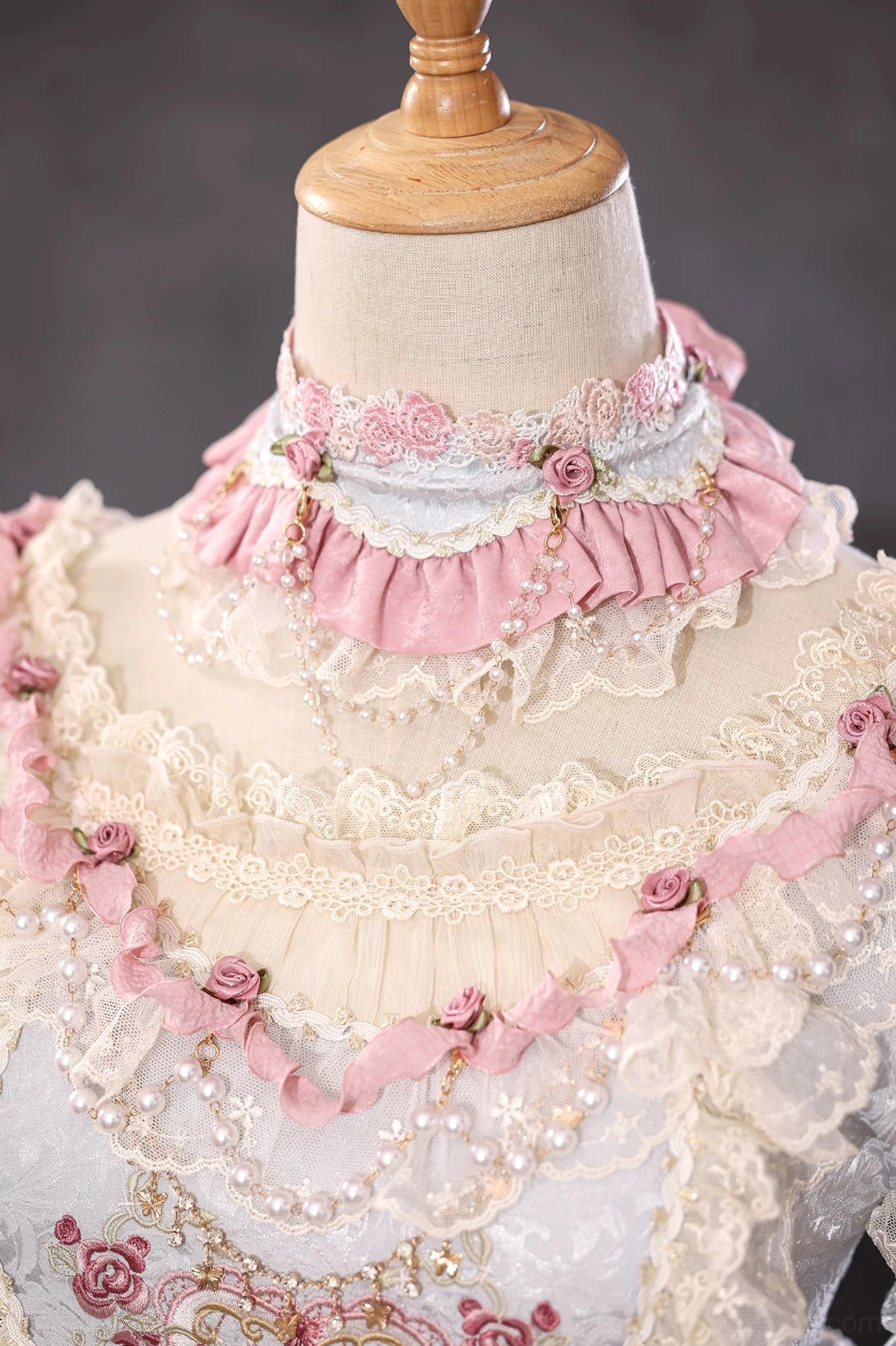 Black and white lolita wrist cuff with pink satin bow, fabric rose featuring pearl detail on wooden mannequin hand