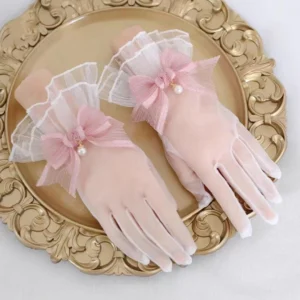 Pink bow sheer lace Lolita gloves with pearl charm worn on mannequin hands beside an ornate vintage gold tray