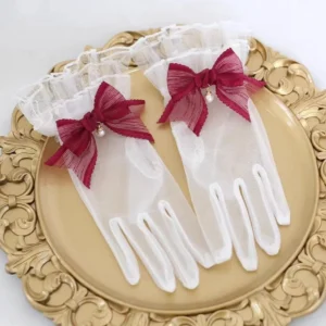 Wine red bow sheer lace Lolita gloves with pearl charm and ruffled wrist cuffs displayed on an ornate vintage gold tray