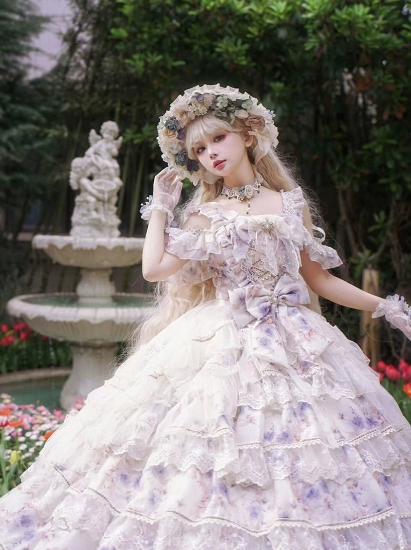 Front three-quarter angled shot of floral printed lolita ball gown with off-shoulder ruffled sleeves, waist bow decoration, layered lace-trimmed skirt and chiffon floral fabric, garden fountain background