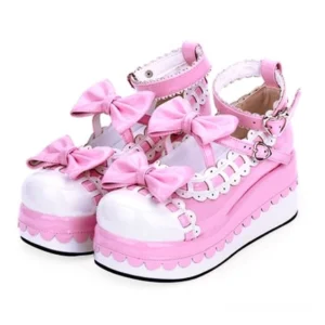 Shining pink and white handcrafted Sweet Lolita platform bow shoes with heart-shaped ankle buckle strap and scalloped sole trim, front three-quarter view on white background