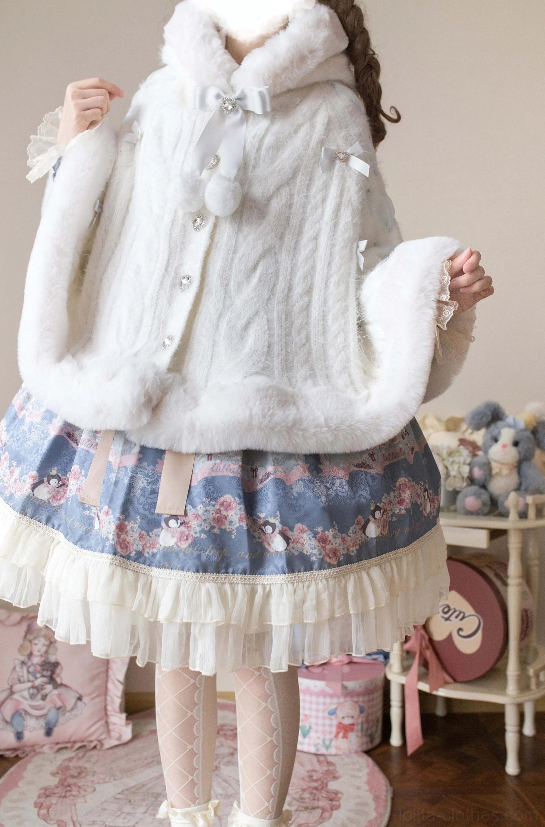 Enchanted winter lolita cape coat showing full product details including faux fur trim, bow collar embellishment, and pom-pom decorations for sweet lolita fashion
