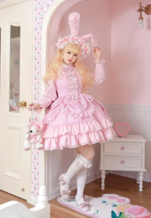 Pink long-sleeve enchanted rabbit lolita one-piece dress worn by blonde model in vintage bedroom setting with bunny ear headwear and white stockings