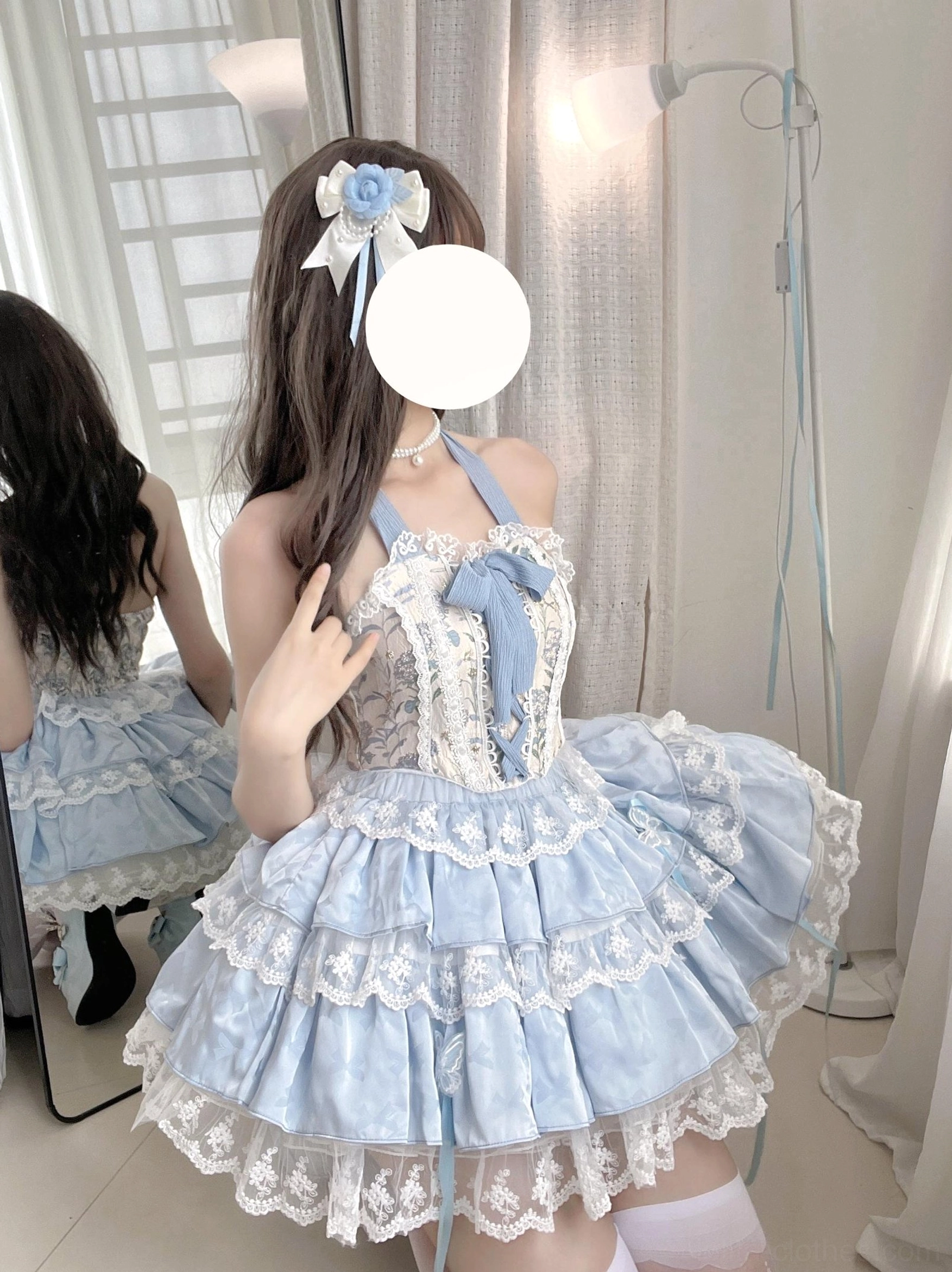 Endless Summer sweet lolita halter bodice skirt set back mirror selfie view sky blue with lace-trimmed tiered skirt and matching hair bow accessory worn by long dark-haired model at fitting mirror