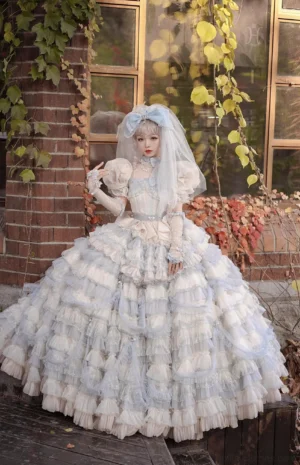 Ethereal bridal reverie sweet lolita ensemble worn on model in outdoor vintage brick courtyard, featuring blue-white gradient multi-layered tulle skirt with puff sleeves, matching bridal headbow and tulle veil, and hand-sewn fishbone corset waist