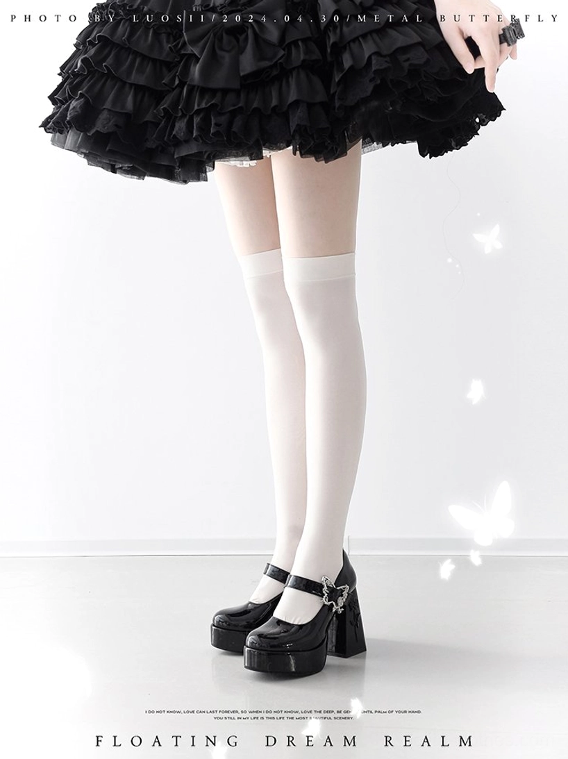 Black Mary Jane platform Lolita heels with chunky block heel and ankle strap buckle on model wearing ruffled black mini skirt and white thigh-high stockings