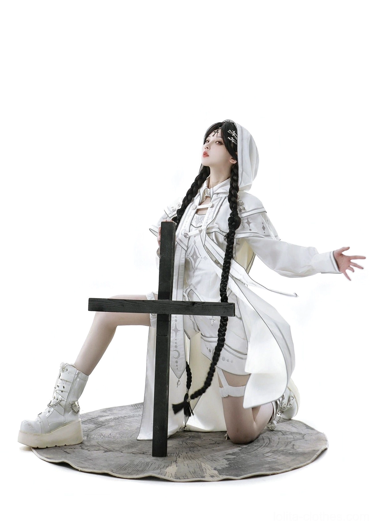 Side kneeling relaxed view of white cyber-lolita cloak ensemble showcasing flowy back hem of long hooded cape, silver stitching, and flowing silhouette in motion