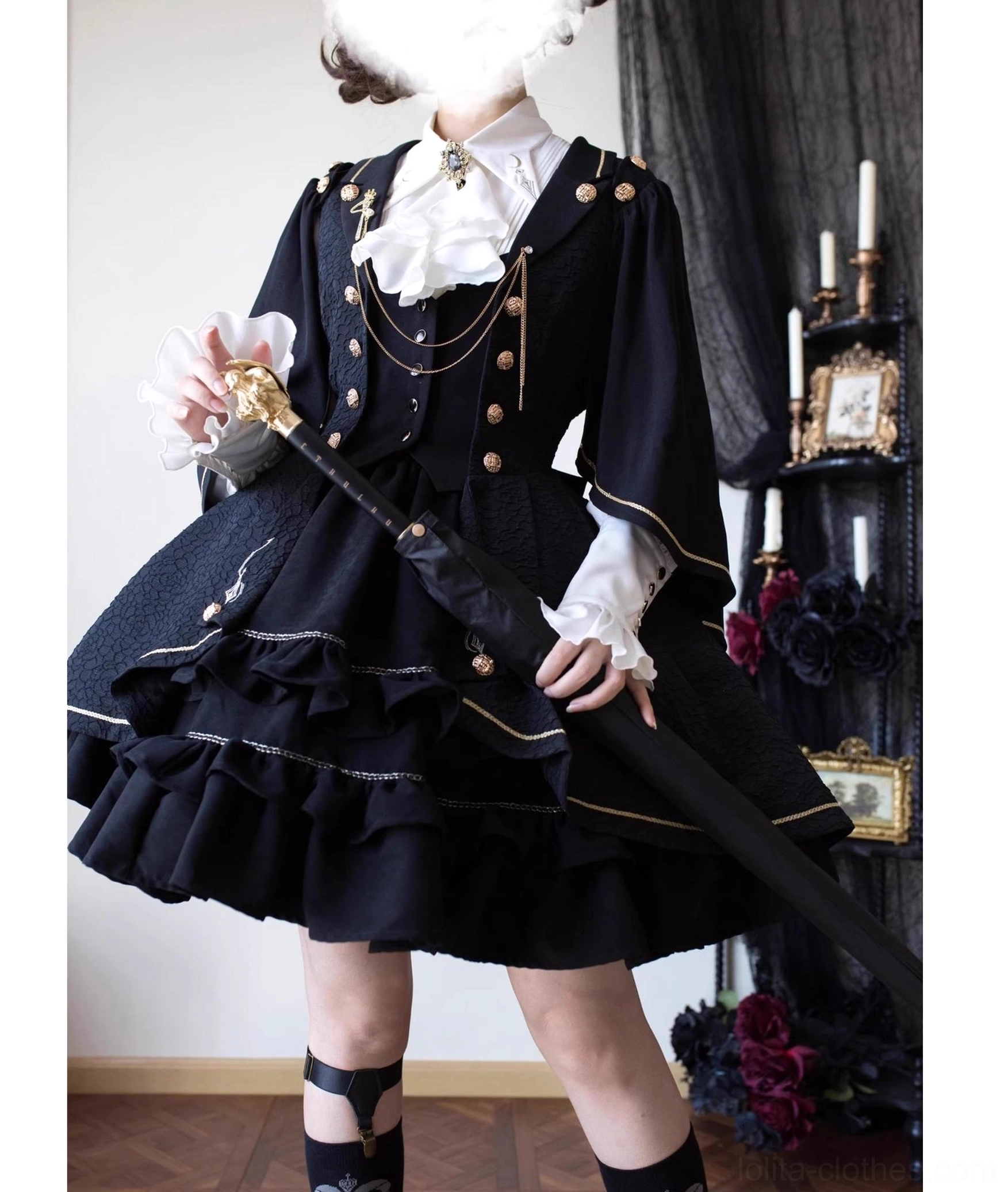 Fallen Moon Rule black and gold retro military lolita dress set, full-body standing indoor display, model in white gloves and leg straps holding decorative walking cane, showcasing gold buttons, chain pendants, tiered ruffles, and formal gothic style
