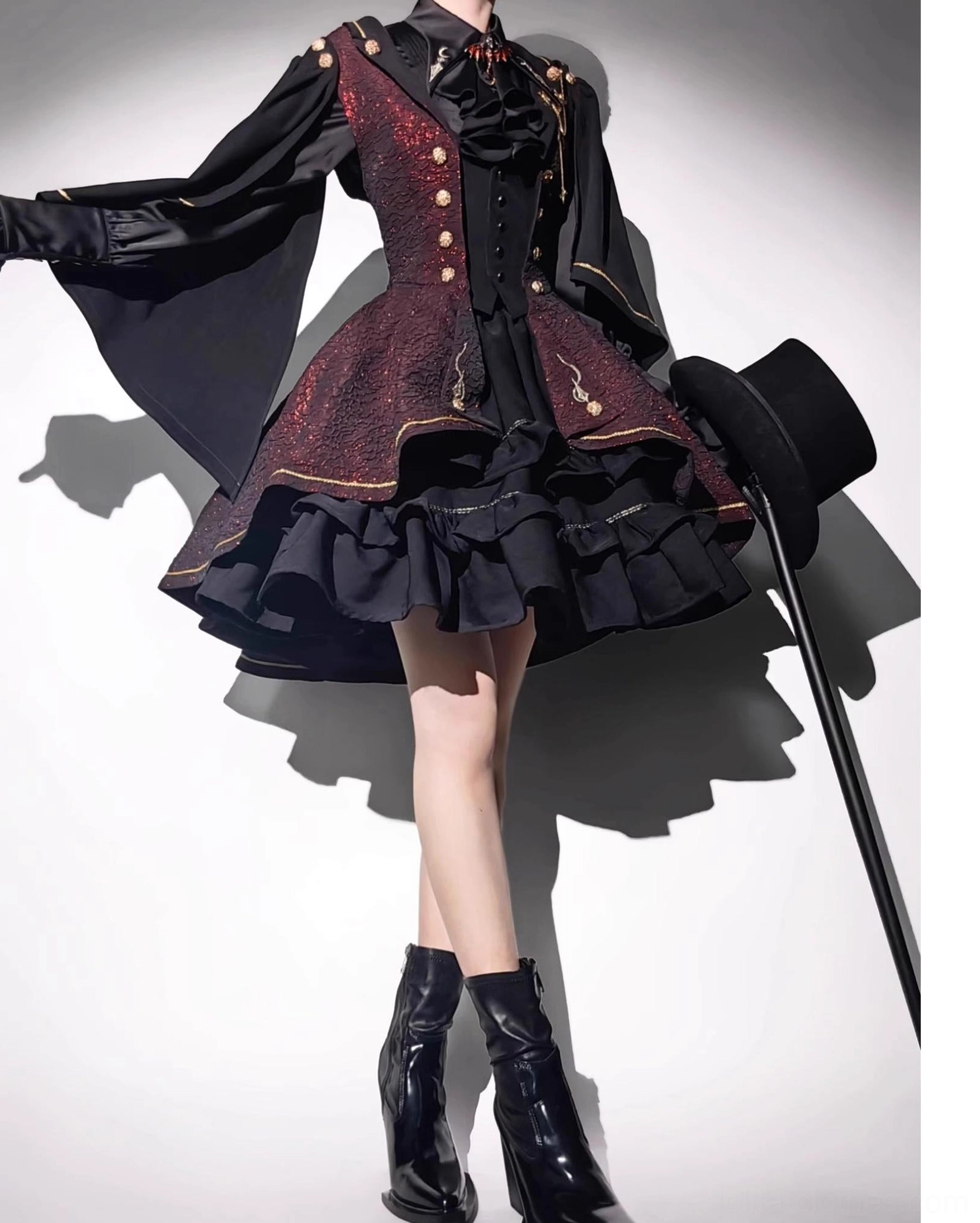 Fallen Moon Rule burgundy and black gothic military lolita dress set, low-angle full-body standing display of model in black ankle boots, with top hat and walking cane, featuring gold button decorated waistcoat and detachable cape sleeves