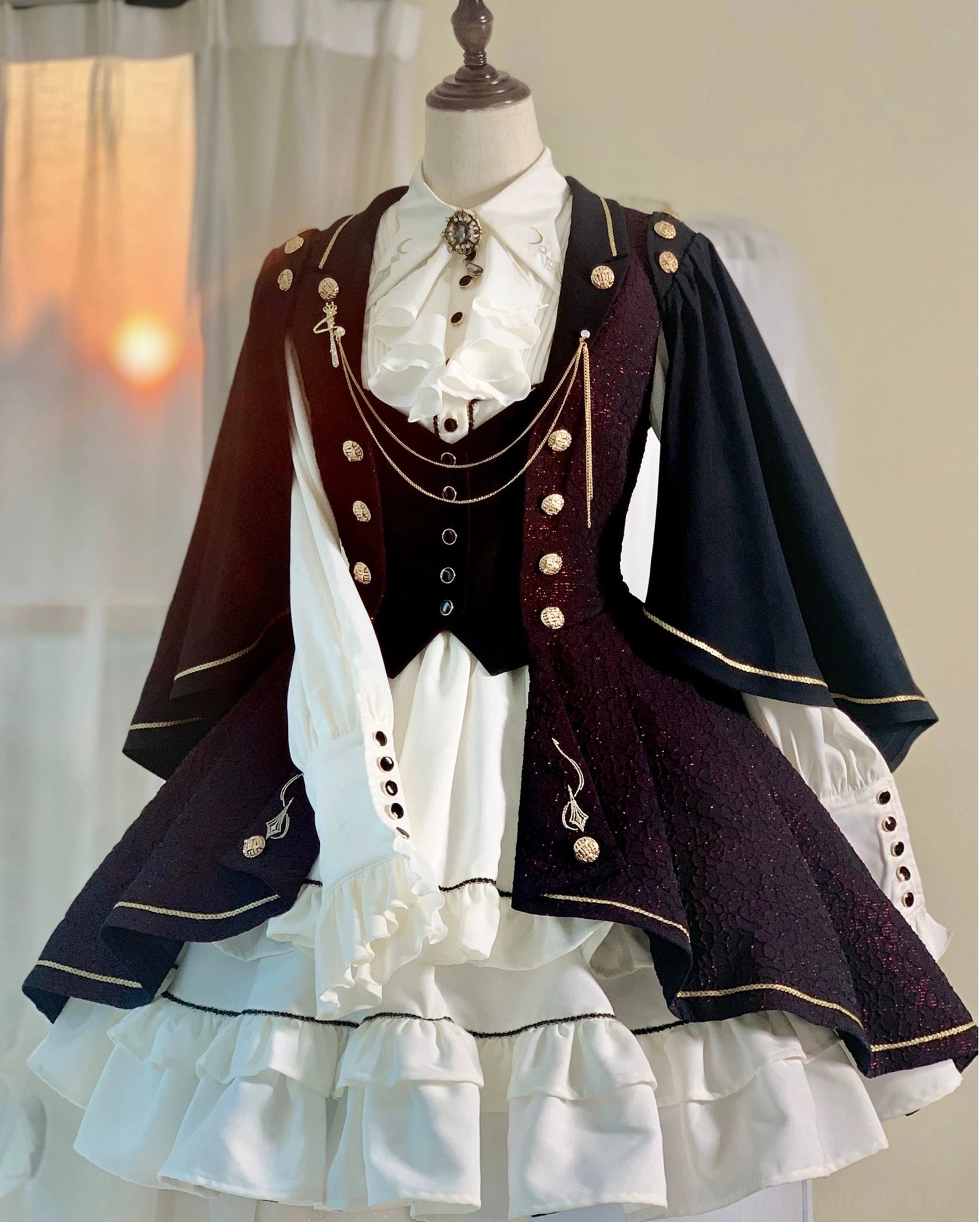 Fallen Moon Rule military lolita waistcoat vest detail, featuring gold button embellishment pattern, structured tailoring, and adjustable back buckle system