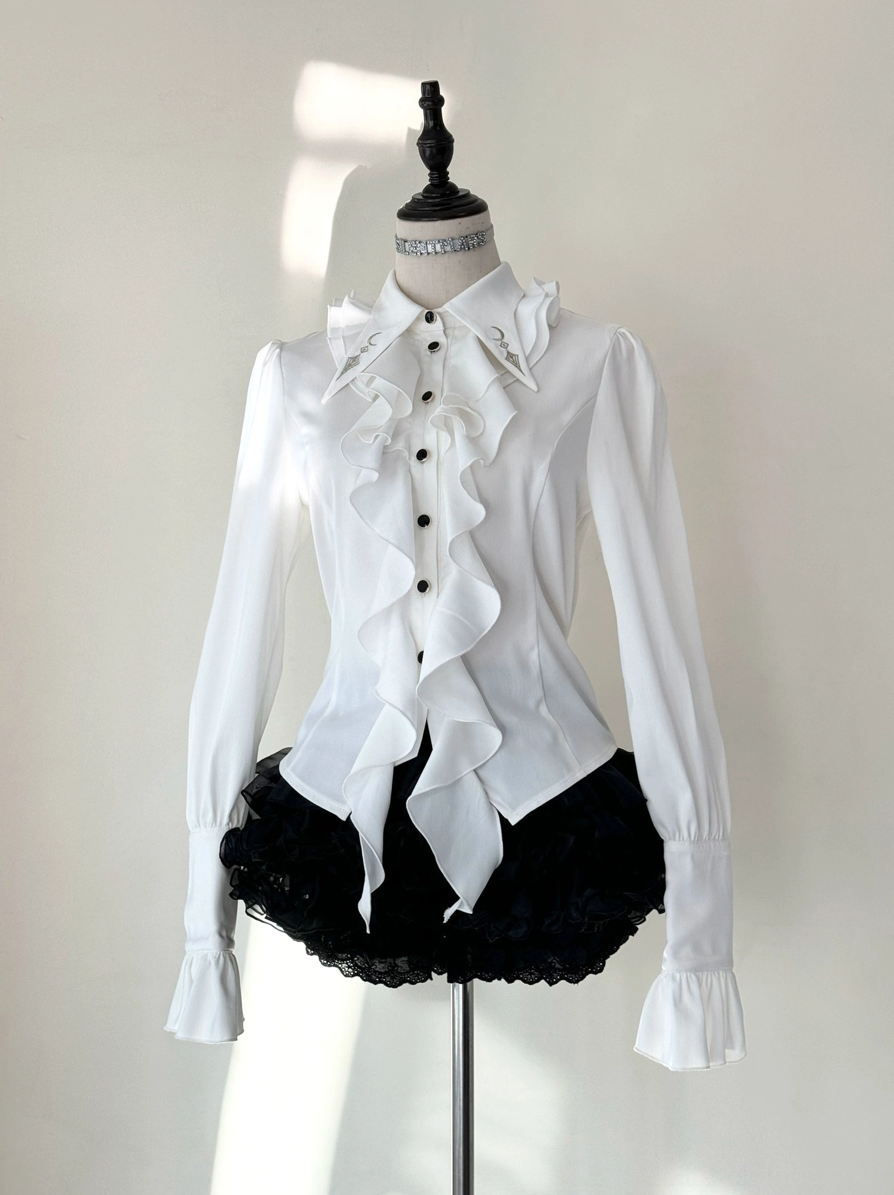 Fallen Moon Rule military lolita blouse and skirt set in white and cream, frontal view on mannequin, showing embroidered collar, gold buttons, ruffled placket, fitted silhouette, and tiered ruffle skirt