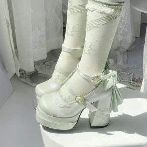Mint green elegant lolita high heel Mary Jane shoes with detachable satin back bow, gem-encrusted buckles, and floral-embellished thick block heel, paired with ruffled embroidered white knee-high socks, low side view