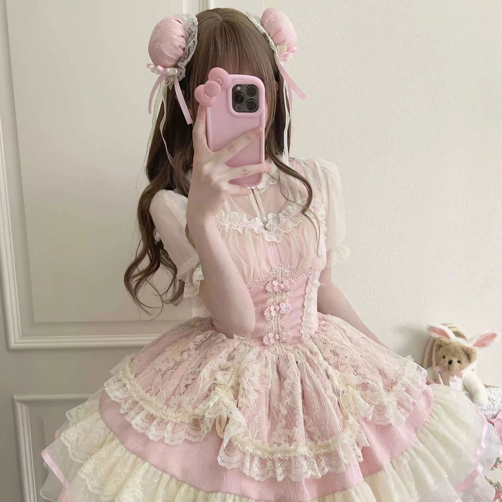 Pink cream lolita jsk dress with stand collar inner blouse and tiered ruffled skirt worn by model taking mirror selfie