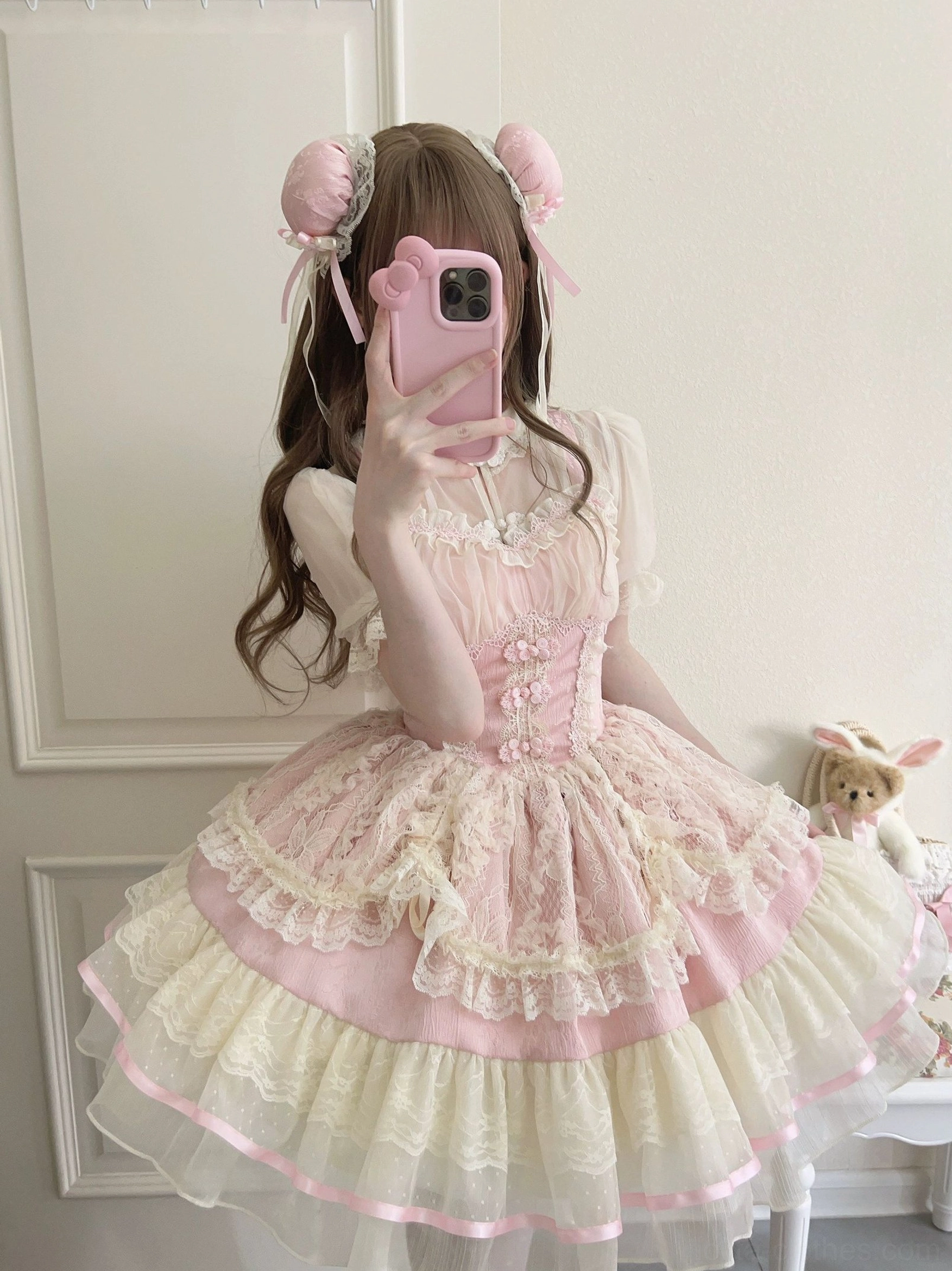 Pink cream lolita jsk dress front mirror view with fitted corset waist lace overlay and tiered ruffled skirt with ribbon hem