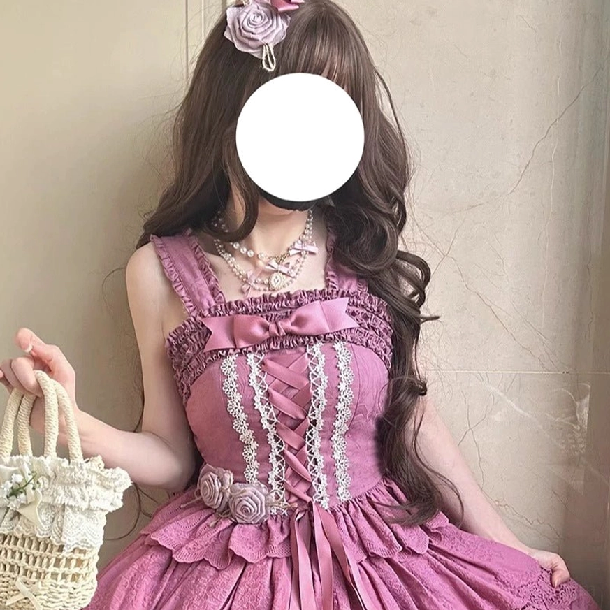 Dusty rose pink Forest Waltz lolita camisole with matching pink bow neckline, white lace trim, lace-up front design, fabric flower waist decoration, and pearl accessories on model
