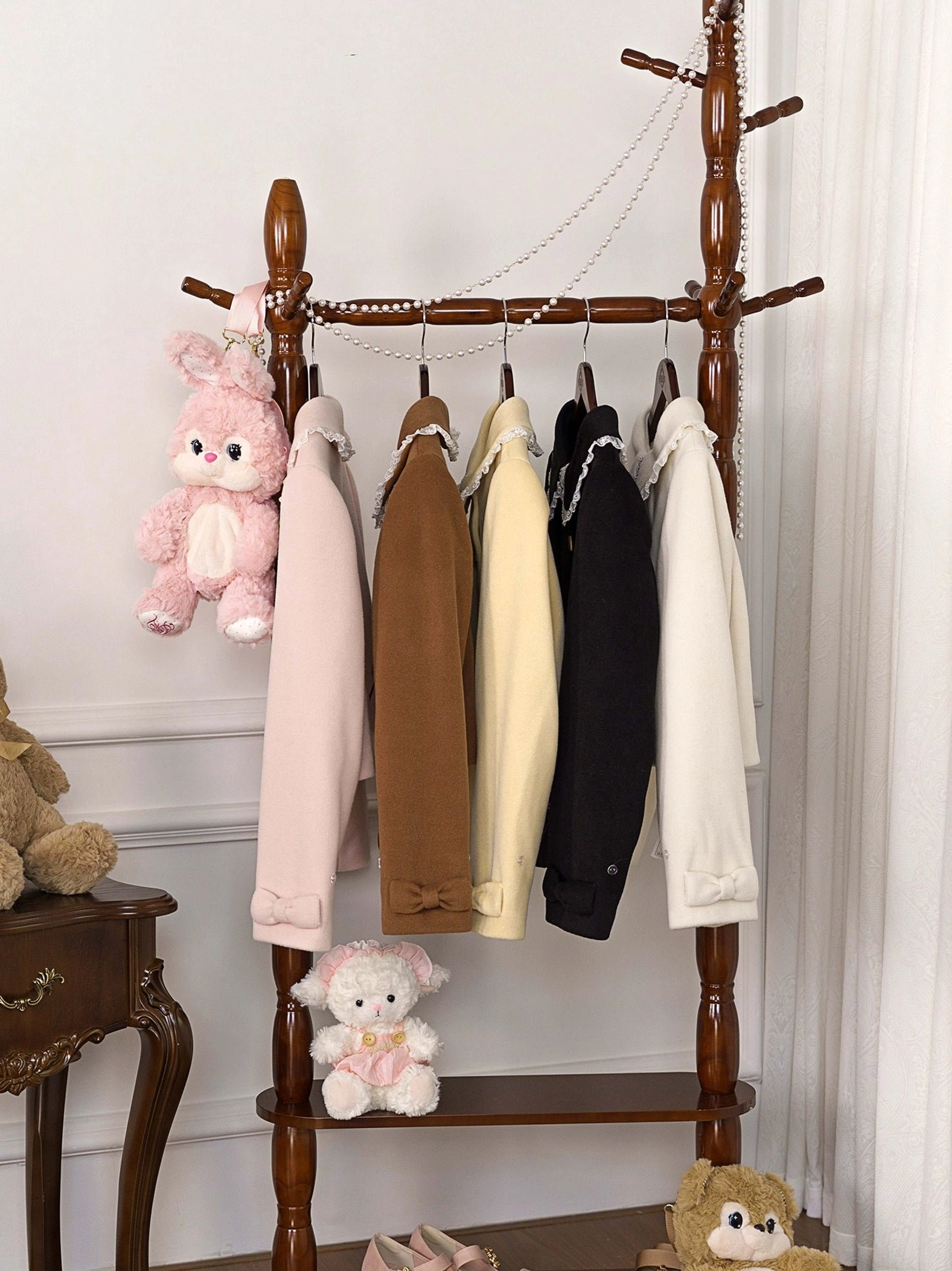 Four-piece sweet lolita winter coat collection in multiple colors showing structured silhouette and minimal design, hanging on wooden rack with decorative styling