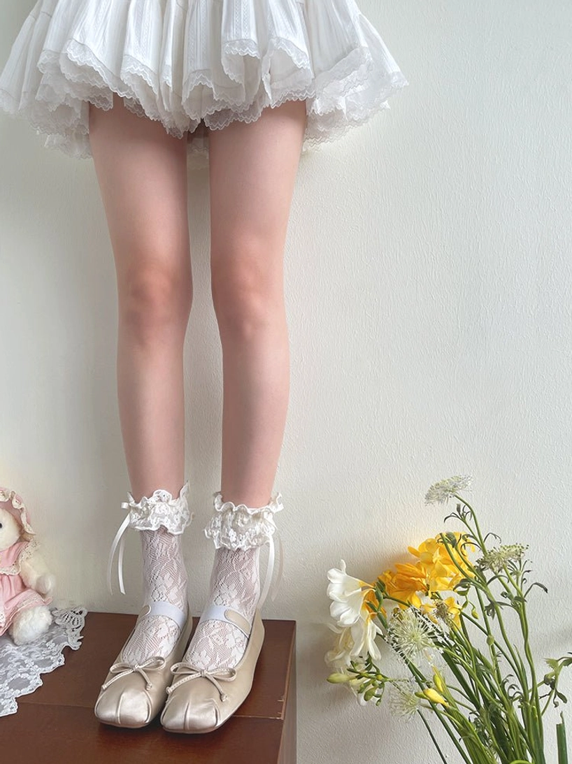 French Lolita mid-calf lace socks full coordinate styling on model wearing white ruffled mini skirt and beige ballet flats, sweet lolita aesthetic on-body view