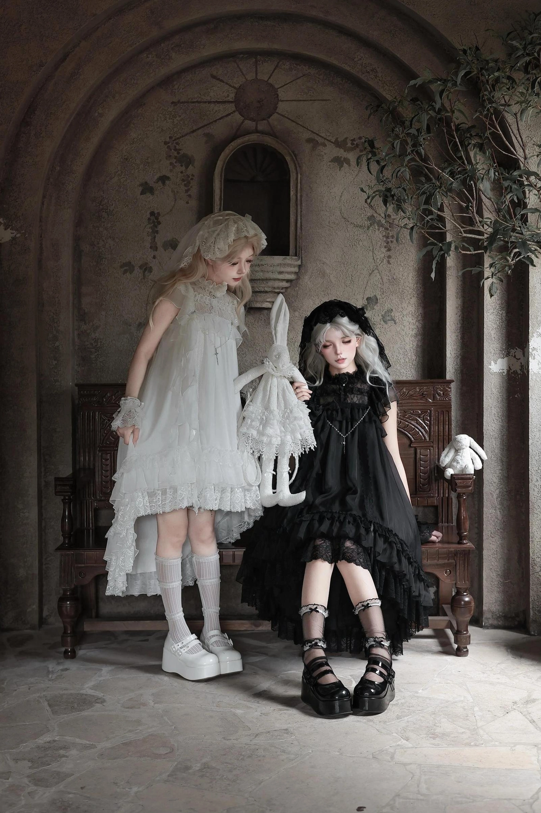 Black gothic lolita OP dress with high ruffled collar, layered tulle ruffled hem, platform combat boots, and plush rabbit hand accessory