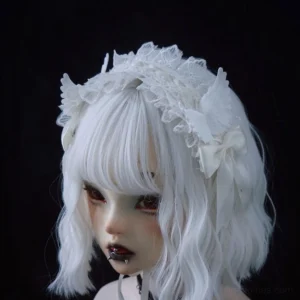 Gothic lolita white lace angel wings hairband worn on BJD bust with white bob wig, left front three-quarter view showing frilled lace details and satin bows