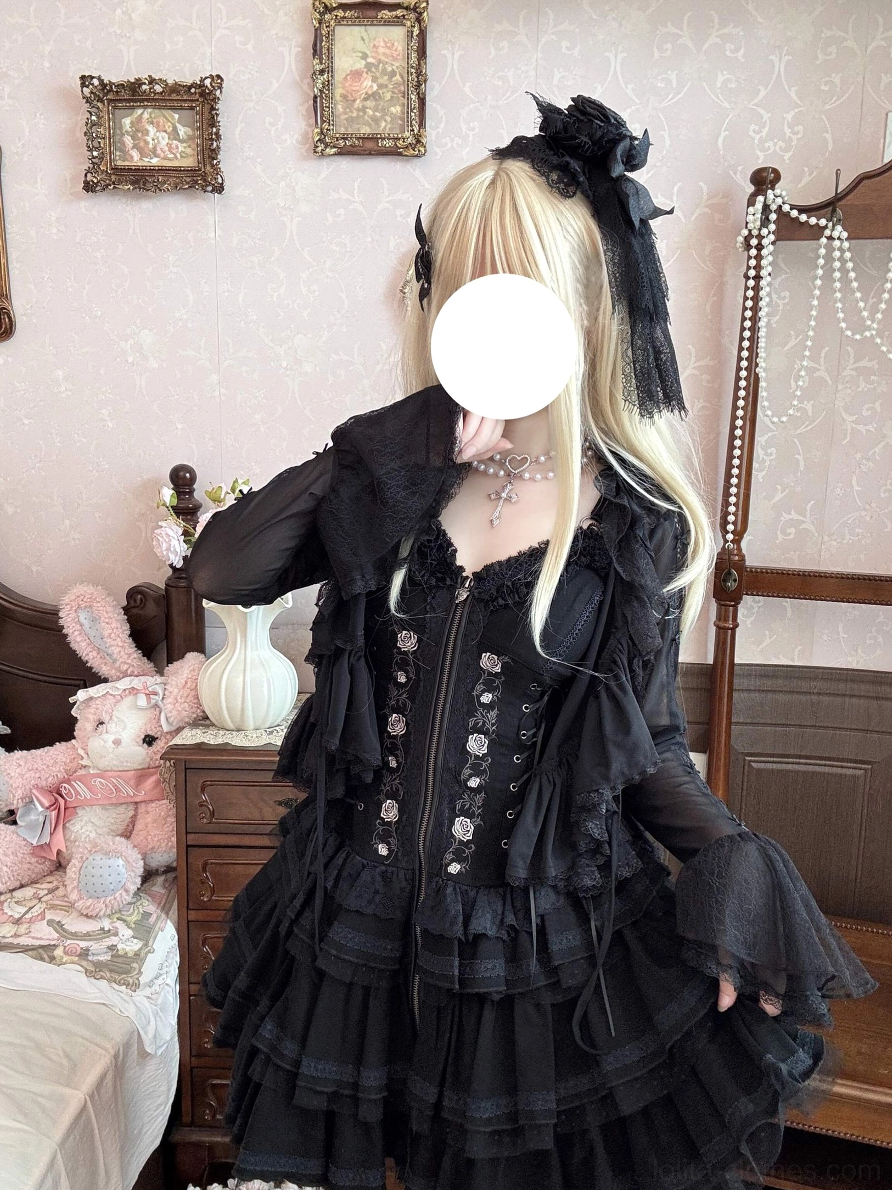 Black gothic lolita bolero cardigan with ruffle trims and decorative buttons, half-body model view in retro bedroom with plush doll decor and sheer bell sleeves