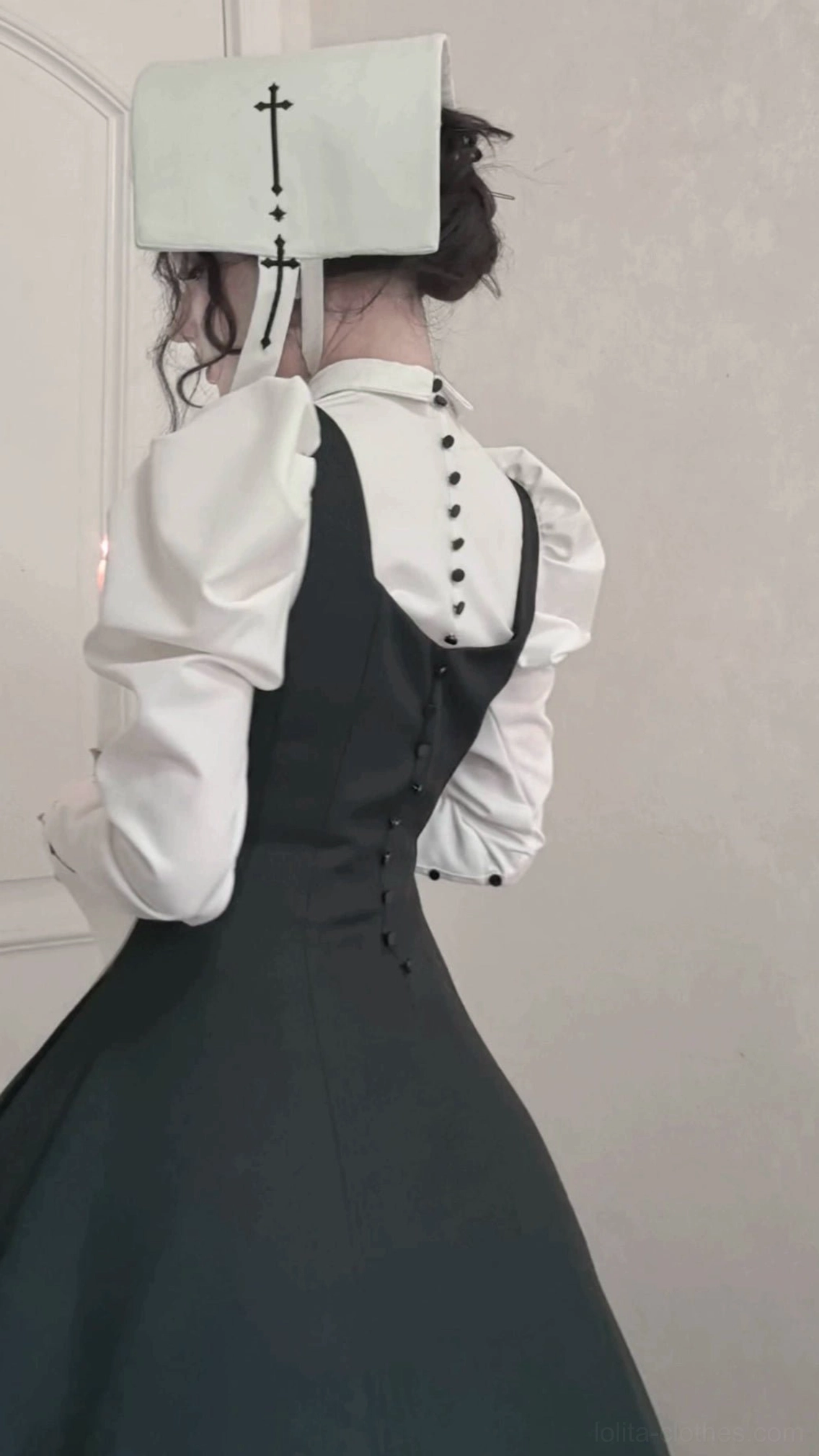 Back view of gothic lolita outfit showing cross-embroidered nun headwear, buttoned back JSK closure and fitted upper garment silhouette