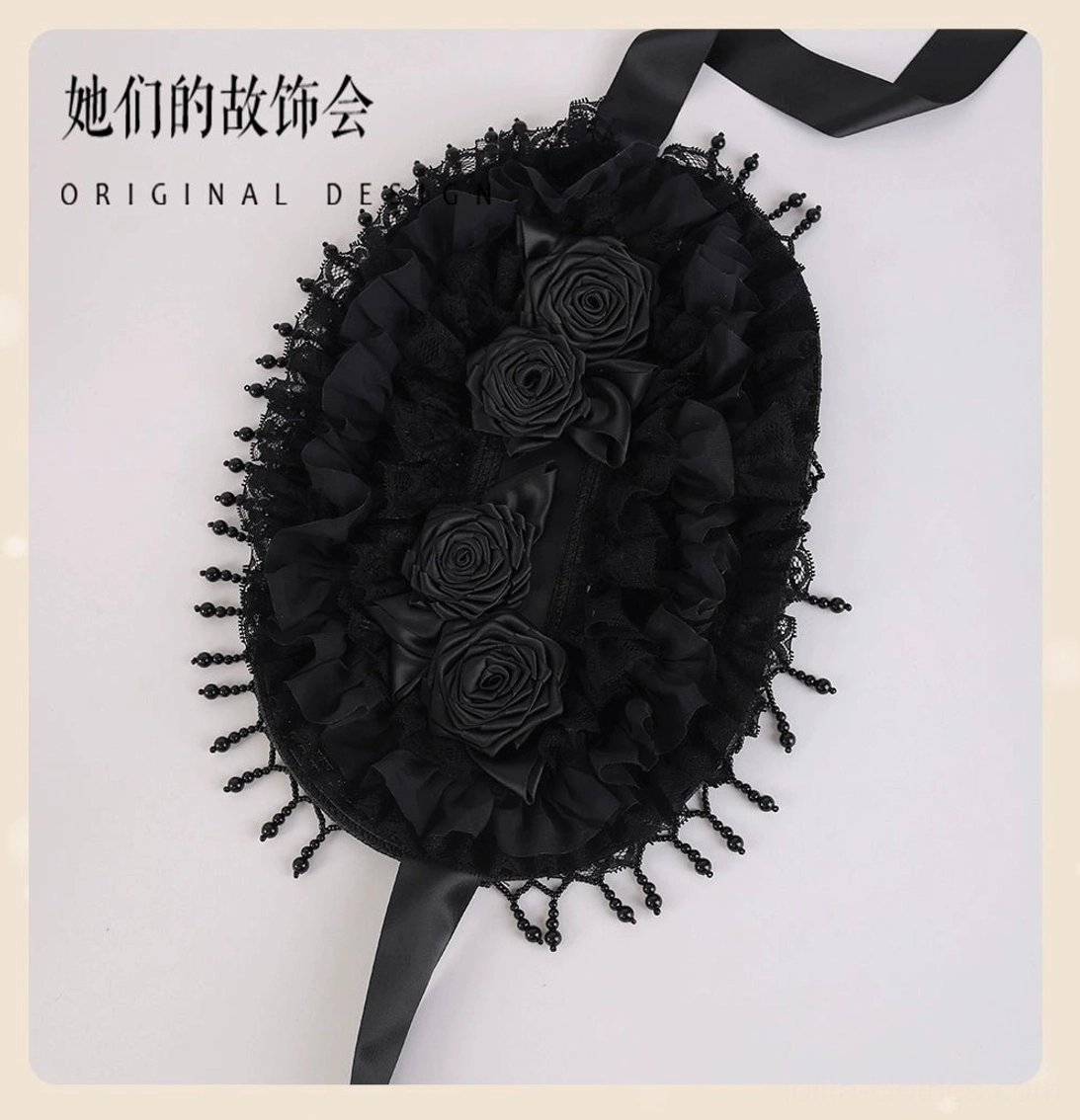 Angled flat lay perspective of Gothic Lolita black bonnet headdress displaying symmetrical rose arrangement, woven black base fabric, extended satin neck tie strap, and structured bonnet silhouette