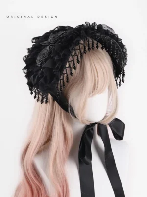Close-up front view of Gothic Lolita black bonnet headdress featuring delicate hand-knotted beaded fringe, layered ruffled lace foundation, and detailed handmade fabric rose decorations on mannequin