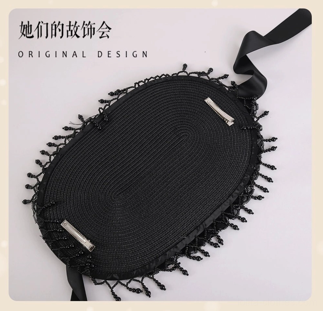 Bottom flat lay view of Gothic Lolita black bonnet hat revealing woven black inner base construction, metal adjustment clips for secure fit, and full perimeter beaded tassel trim detail