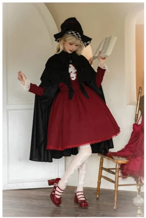 Gothic Lolita black cape styled with red dress full body front view witch hat model indoor study room aesthetic
