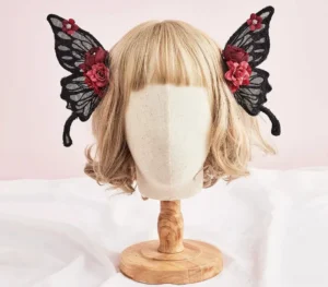Pair of Gothic Lolita black lace butterfly wing hair clips positioned symmetrically on both sides of blonde wig front view overhead perspective