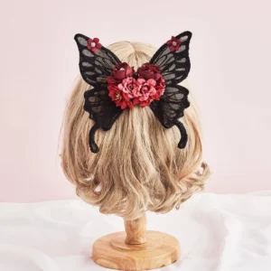 Gothic Lolita black lace butterfly wing hair clips displayed on short blonde wig from back overhead view showing burgundy flower and red bead decoration details