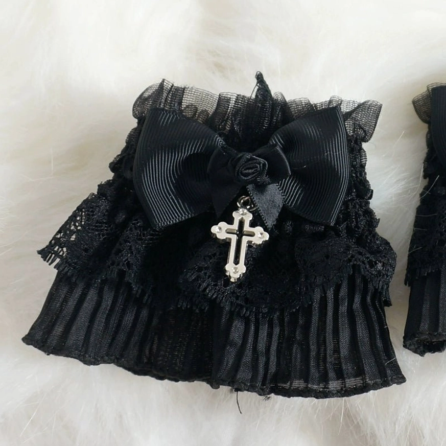 Close-up front view of single Gothic Lolita black lace wrist cuff showing detailed ruffle lace, satin bow, rose accent and silver cross pendant