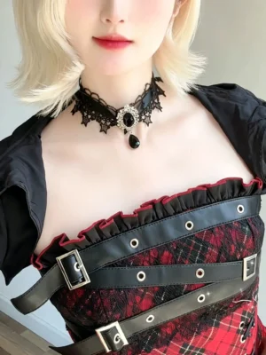 Gothic lolita black rhinestone lace choker with teardrop pendant worn by model in red-black plaid dress close-up front view