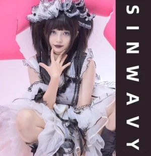 Model wearing Gothic Lolita black twin ponytail wig with matching black and white lace dress and Gothic makeup aesthetic half-body front view