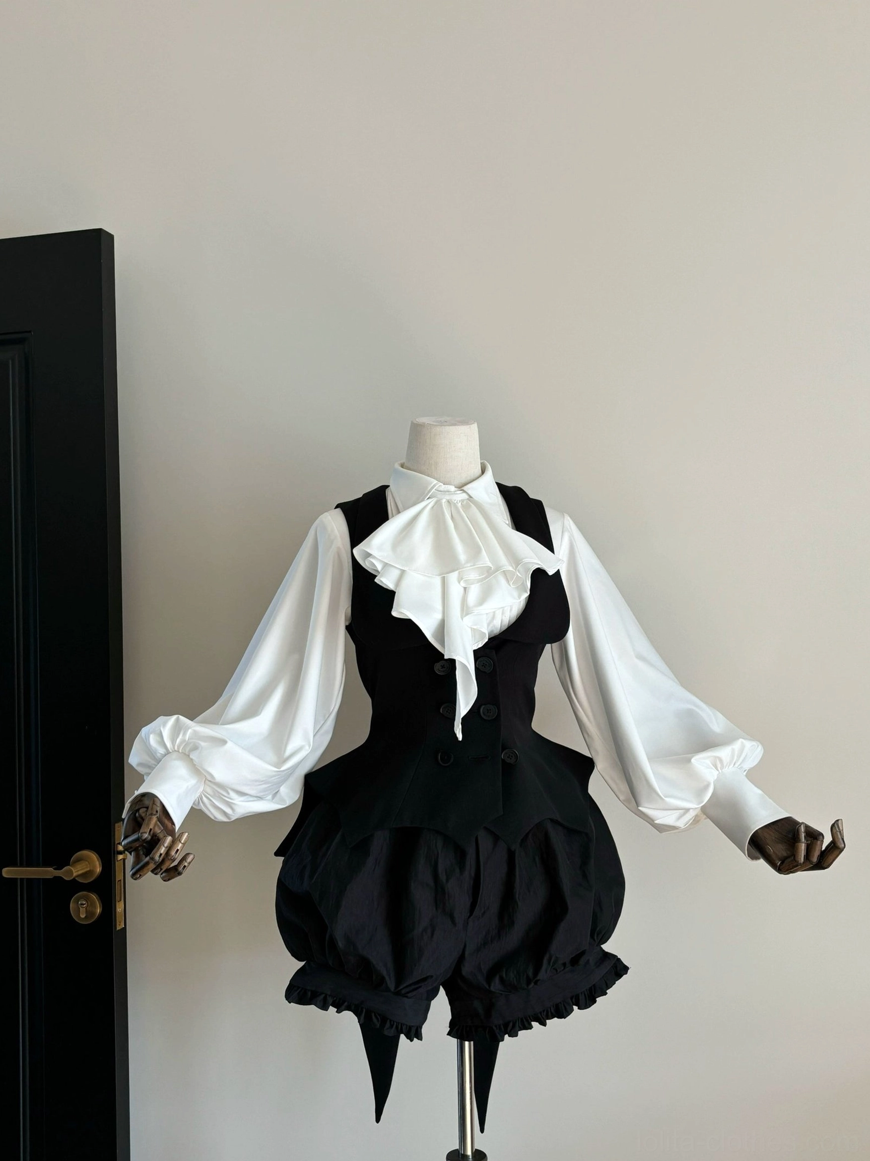 Gentleman-style Gothic Lolita outfit with white ruffled bow neck cravat, white puffed long-sleeve blouse, black waistcoat and black puffed bloomer shorts featuring bat-wing hem tail