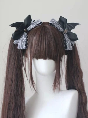 Black and white gothic lolita batwing hair clips with satin bows and lace trim on mannequin displaying twin tail hairstyle from front angle