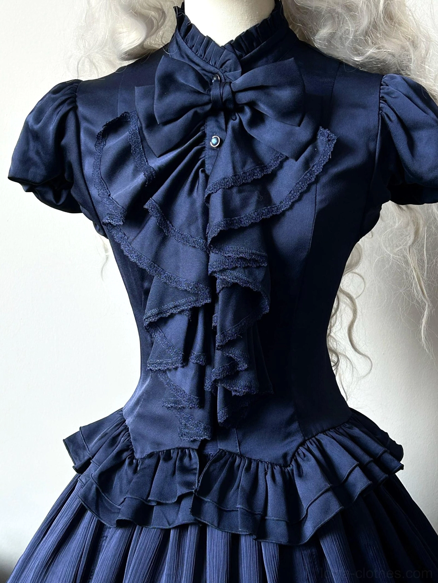 Navy blue Gothic Lolita fitted blouse close-up front view dress form stand collar ruffled bow detail puff sleeves layered flounce hem