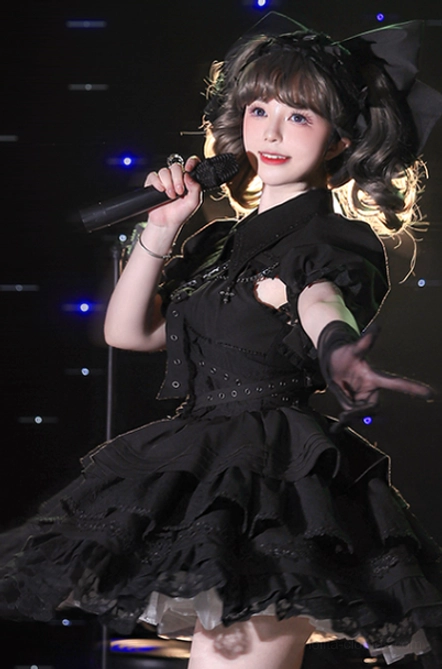 Full black gothic lolita stage performance outfit bolero puff sleeves layered ruffled skirt bow hair ornament dark goth styling half-body portrait cosplay