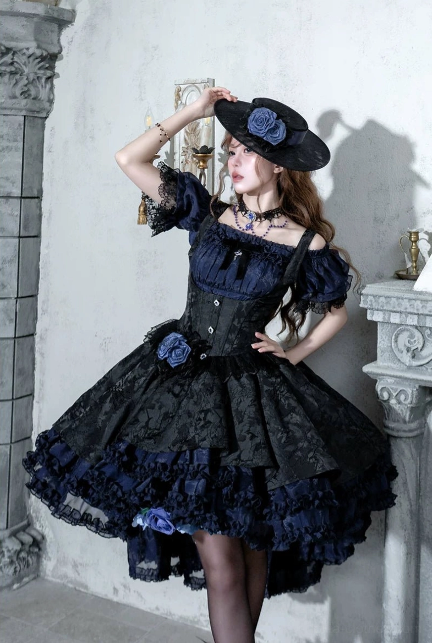Navy-blue black Gothic Lolita boned JSK dress three-quarter front view with off-shoulder puff sleeves, fabric brooch decorations and high-low ruffled skirt