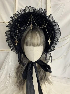 Gothic Lolita black bonnet headdress front close-up view with ruffled mesh brim, gold cross pendant chains, and black satin chin ties