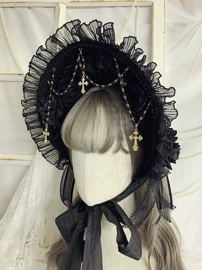 Gothic Lolita bonnet headdress front three-quarter angle showcasing ruffled lace trim, cross charm metal chains, and black satin fastening ribbons