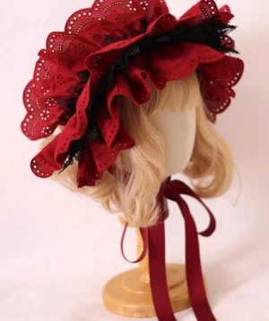 Classic Gothic lolita bonnet hat with wine-red ruffled lace brim and black lace trim, left side three-quarter view on blonde mannequin with wooden display stand