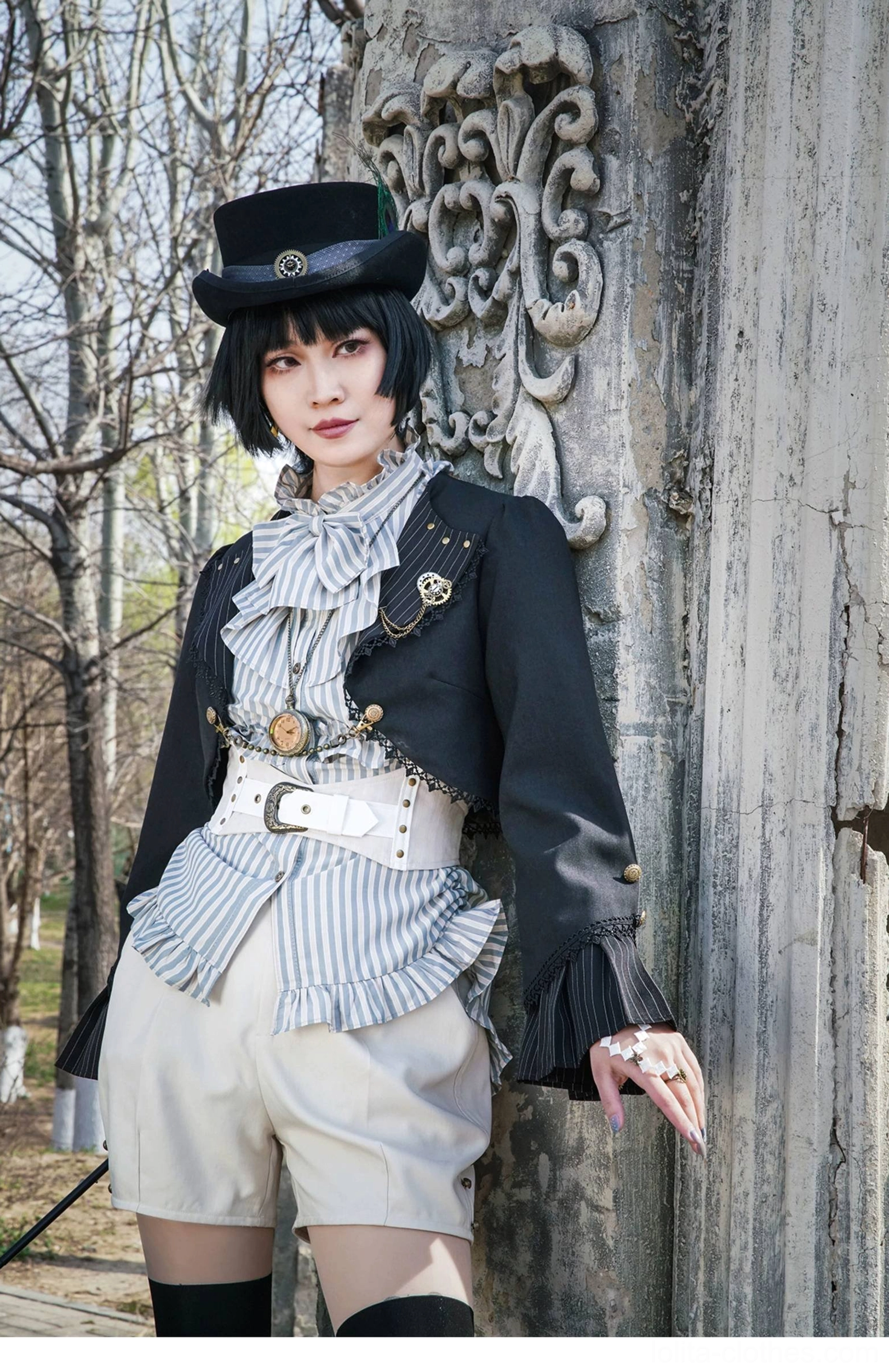 Full body side leaning pose model wearing Gothic Lolita cardigan against weathered stone pillar in vintage park scenic background