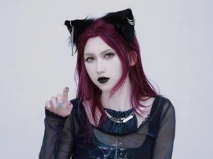 Gothic Lolita cat ear headdress with silver cross chain ornament worn by model with wine-red hair and dark gothic mesh top - front view