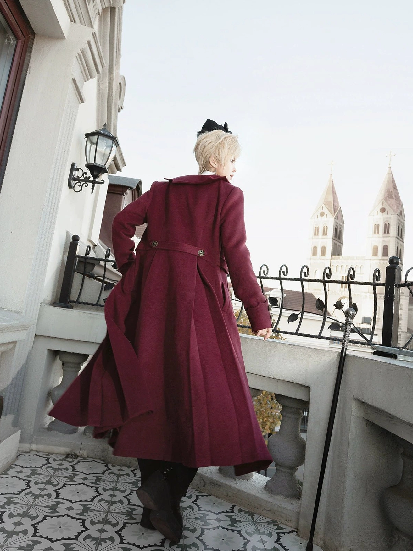 Dracula-inspired gothic lolita ensemble full back view outdoor european balcony belted waist detail burgundy velvet coat sleek silhouette church backdrop vintage setting