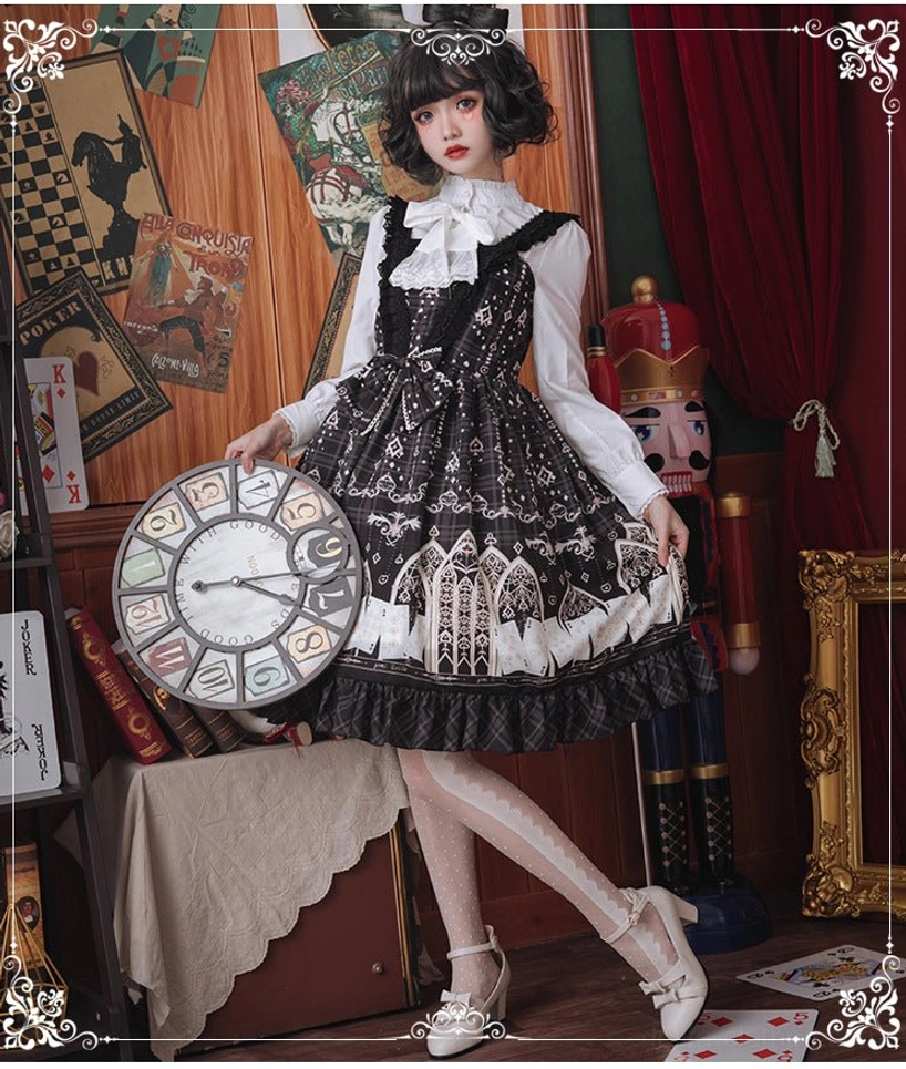 Full gothic Lolita outfit coordination with black jumper skirt and white stand collar blouse worn by model in vintage studio with theatrical props